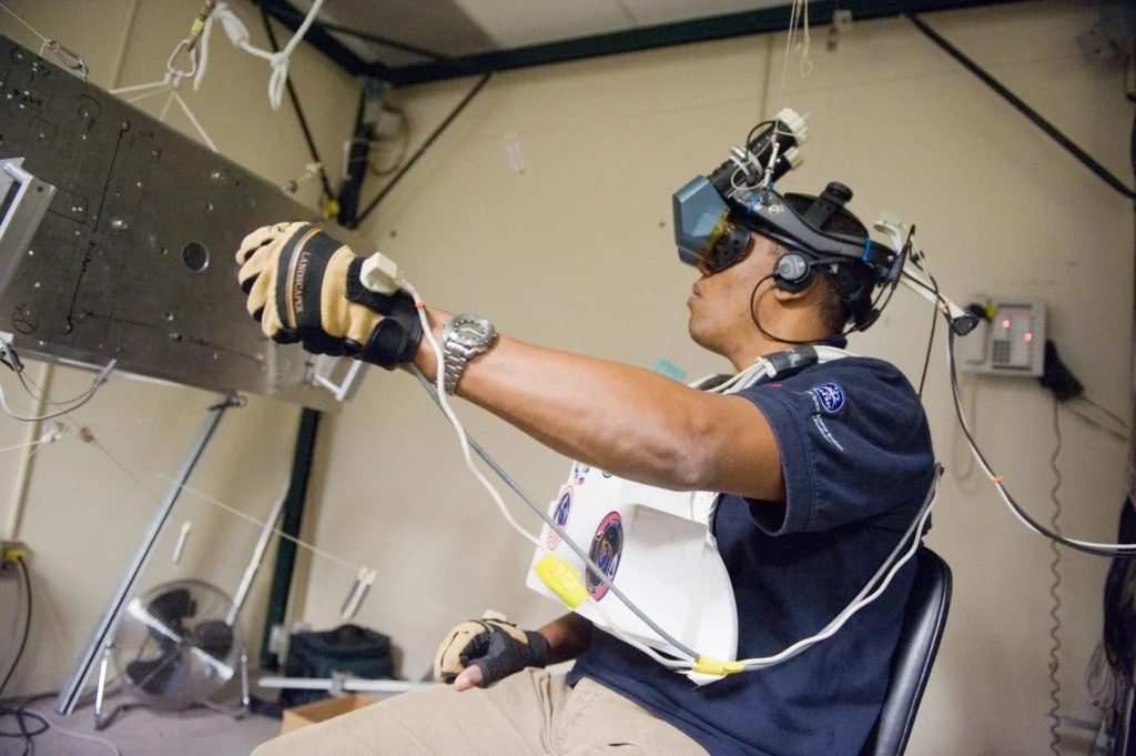 vr_precision_training A man using a vr headset and haptic gloves to learn a precision task